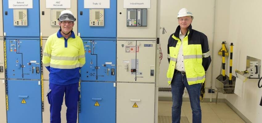 two men standing in front of electrical equipment